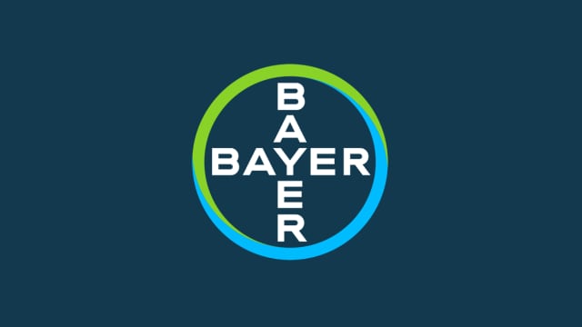 Bayer logo featuring the word "BAYER" in a vertical and horizontal arrangement within a blue and green circle on a dark blue background.