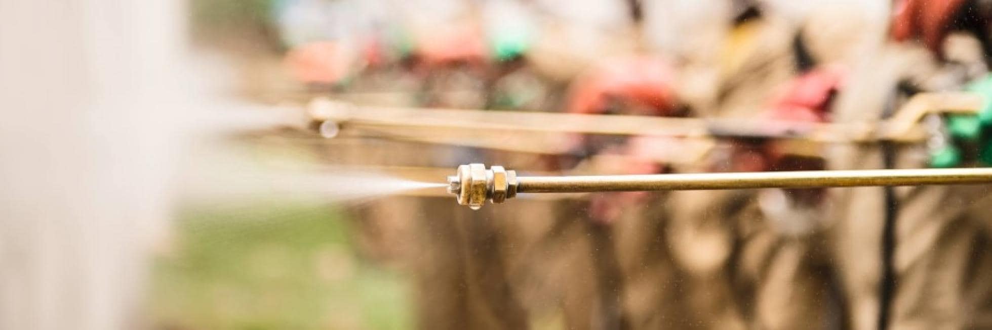 Close-up of a spraying nozzle releasing water, part of agricultural irrigation equipment.